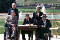 President George H.W. Bush signs the Americans with Disabilities Act on the White House lawn surrounded by Evan Kemp, the Rev. Harold Wilke, Justin Dart Jr., and Sandra Parrino.